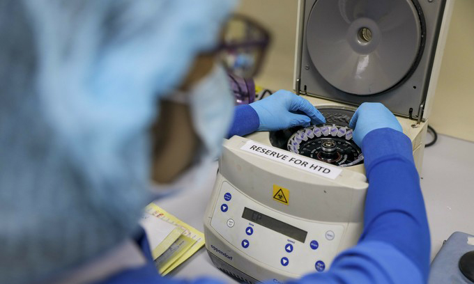 A nurse puts samples taken for Covid-19 testing at a laboratory inside HCMC Hospital for Tropical Diseases